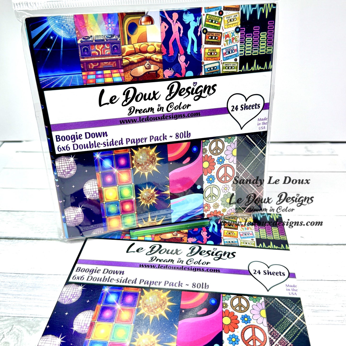 Le Doux Designs paper pack with colorful designs on a white wooden surface