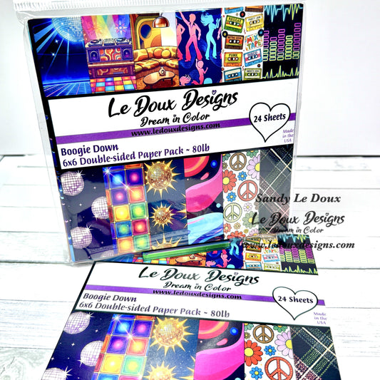 Le Doux Designs paper pack with colorful designs on a white wooden surface