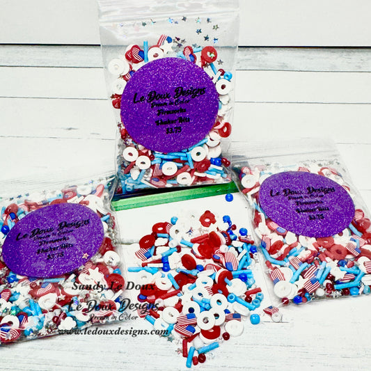 Three bags of patriotic-themed decorative items with 'Le Doux Design' branding on a wooden surface.