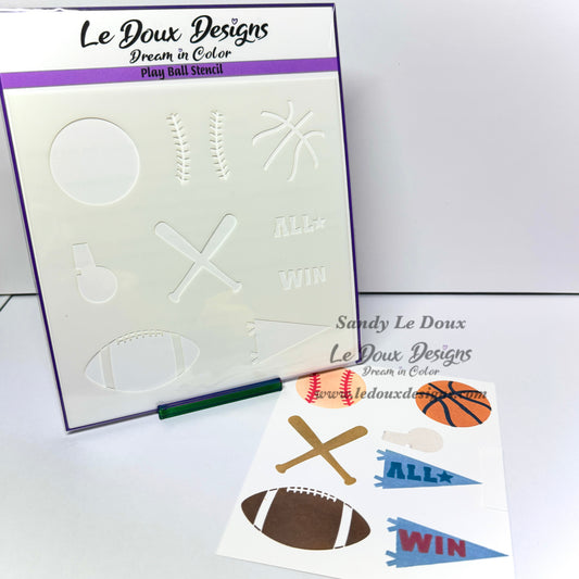 Le Doux Designs play ball stencil kit showing the white stencil board with embossed sports shapes,  and sample printed sticker sheets with football, basketball, bat, whistle, and pennant designs.